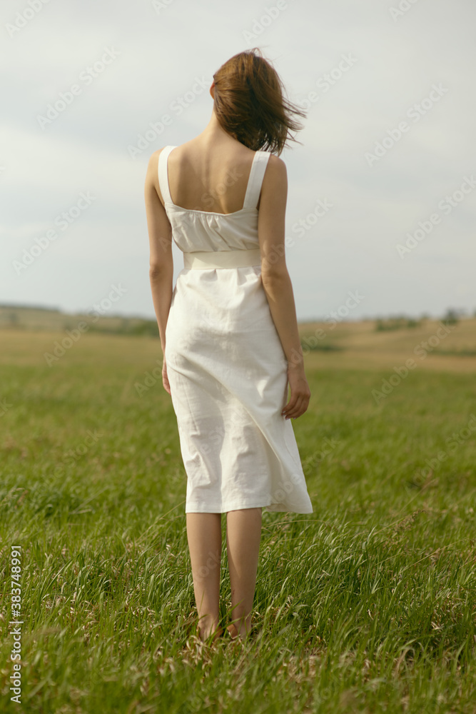 Nice picnic on the grass. Young beautiful woman in the middle of green field. Summer landscape, good weather. Windy day with sun and clouds. Cotton white suit eco style. Nice picnic on the grass. Young beautiful woman in the middle of green field. Summer landscape, good weather. Windy day with sun and clouds. Cotton white suit eco style.