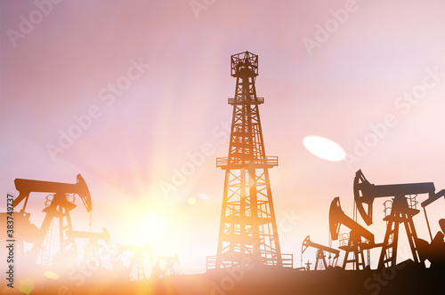 Darck silhoutte of oil rig and pumps during sunset