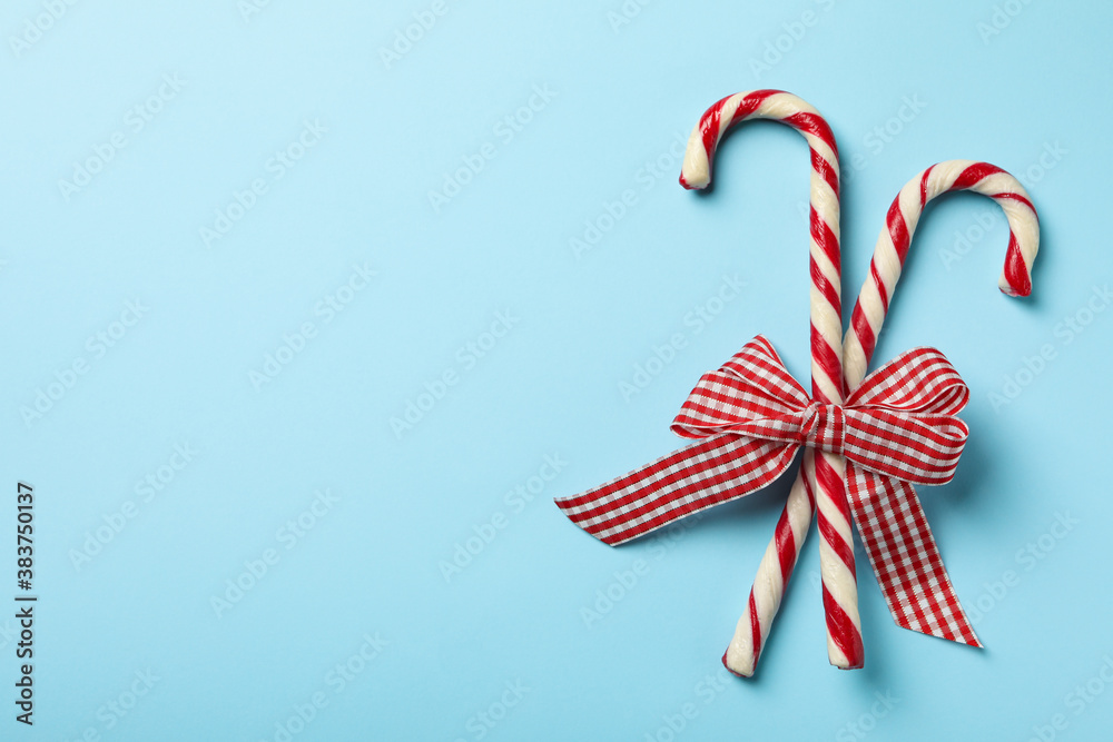 Checkered gift bow with candy canes on blue background Checkered gift bow with candy canes on blue background