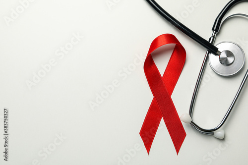 Red awareness ribbon and stethoscope on white background photo