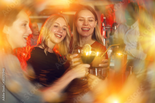 Female friends enjoying wine in night club. High quality photo