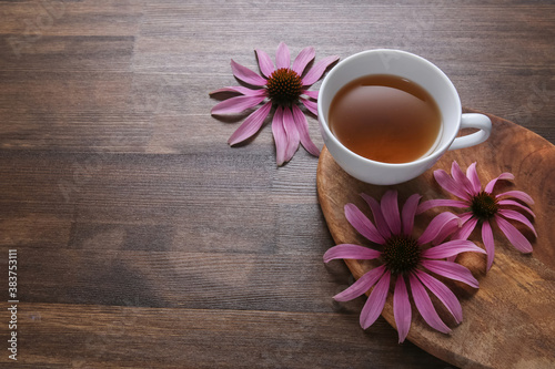 echinacea flowers on wooden background with tea