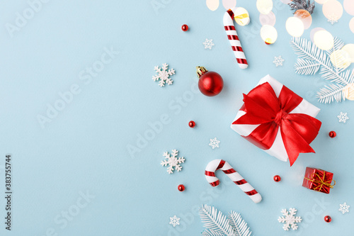 Red gift box with Christmas decorations on blue background
