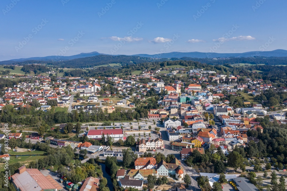 Bild einer Luftaufnahme mit einer Drohne der Stadt Grafenau im bayerischen Wald mit Bergen Arber Rachel und Lusen im Hintergrund, Deutschland