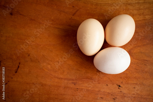 Three fresh white eggs on a wooden table 木製テーブルの上の三つの新鮮な白い卵