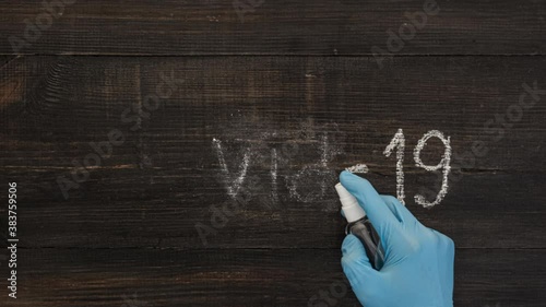 Stop motion animation with lettering COVID-19. Leters on a dark wooden background. The concept of destroing of virus. photo