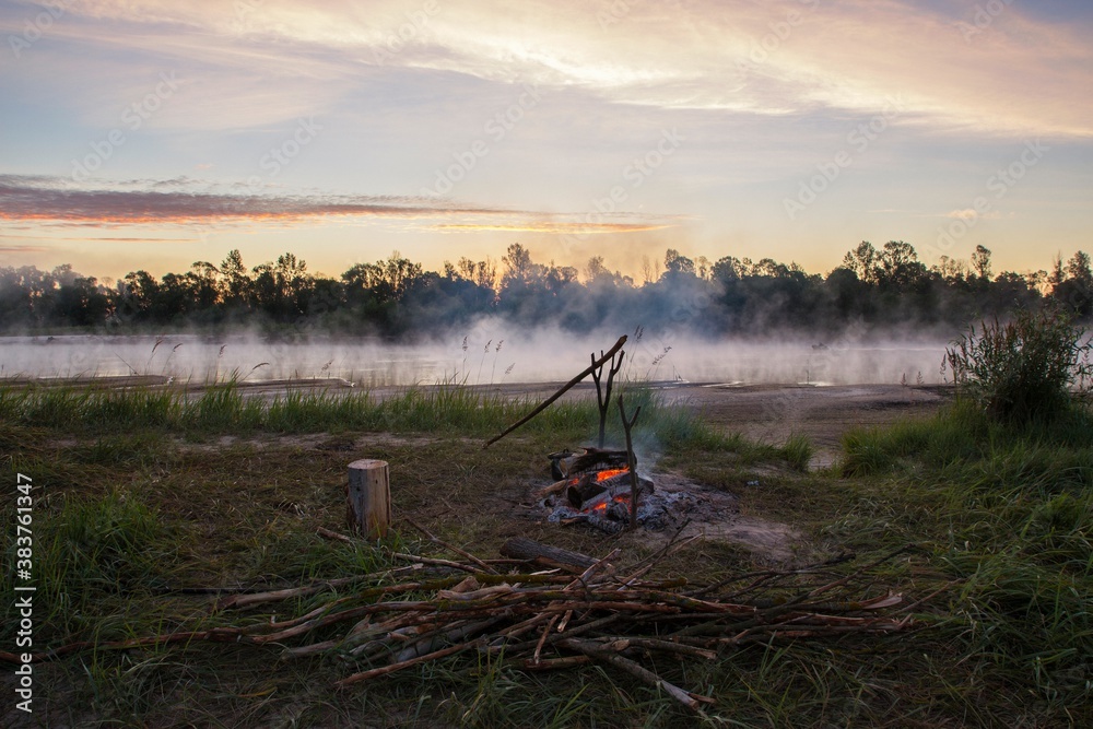 Fototapeta premium Early morning on the river with fading bonfire