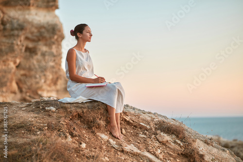 Dreamy woman write thoughts in notebook. Pensive mood and fresh air. Keeping diary and time alone concept, copy space