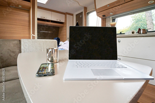 Homeoffice Arbeiten im Wohnwagen Wohnmobil mit Laptop und Internet im Urlaub unterwegs auf dem Campinglatz  photo