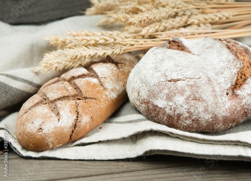 Assortment of baked bread and wheat on the wooden