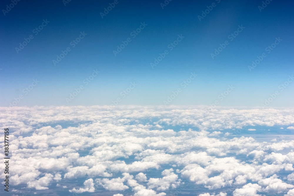 View from the plane window to cumulus clouds and blue sky. View from the plane window to cumulus clouds and blue sky.