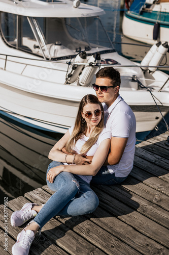 Close up of happy young couple sit on the sea harbor © Роман Котиков