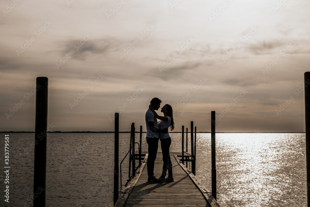 Silhouette photo of romantic couple enjoying sunset harbor view