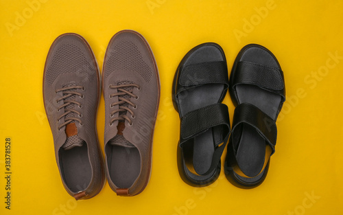 Men's shoes and women's sandals on yellow background. Top view