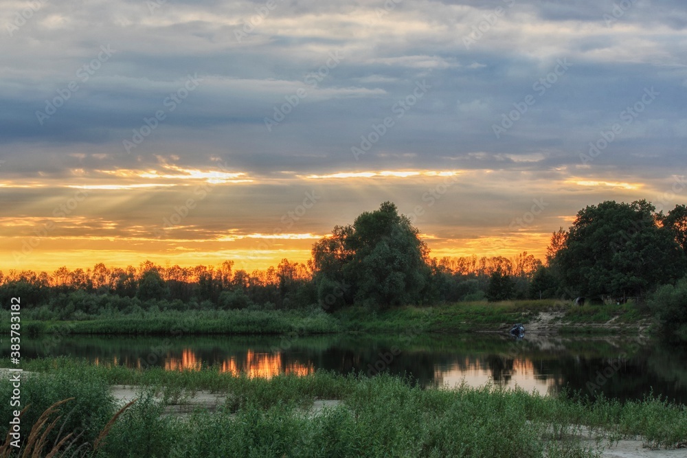Naklejka premium Bank of river on sunset
