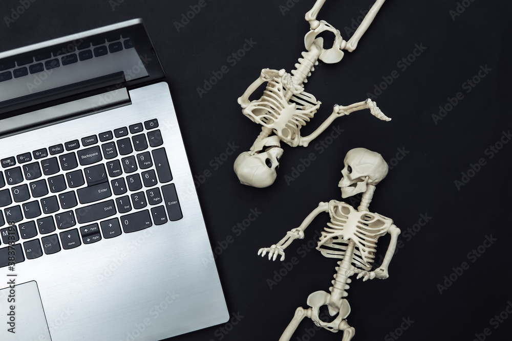 Laptop and skeletons on black background. Halloween theme. Top view Stock  Photo | Adobe Stock