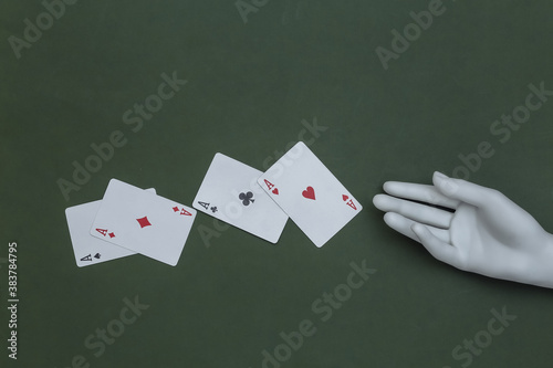 Four aces and mannequin hand on green background photo