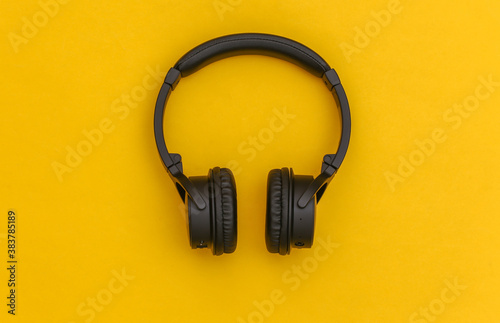 Wireless stereo headphones on yellow background. Top view