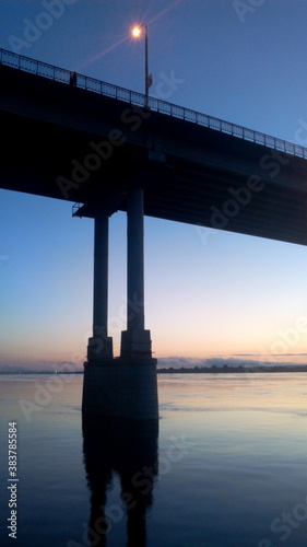 Sunset river bridge sky clouds. RIver bridge sunset scene. Sunset river brisge landscape photo