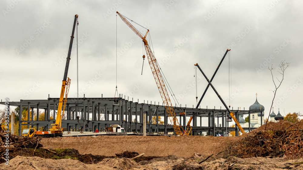 construction site with high-rise cranes in cloudy weather