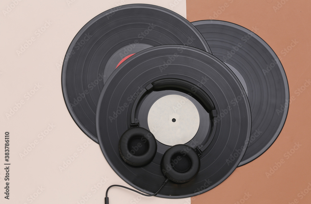 Retro vinyl records and stereo headphones on a brown beige background. Top view. Flat lay Retro vinyl records and stereo headphones on a brown beige background. Top view. Flat lay