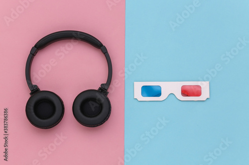 3d glasses and stereo headphones on blue pink background. Top view. Flat lay