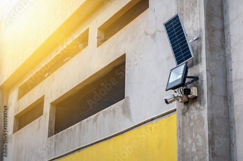 CCTV Camera with LED spot light and solar panel on wall, innovation for home security © Mojijung