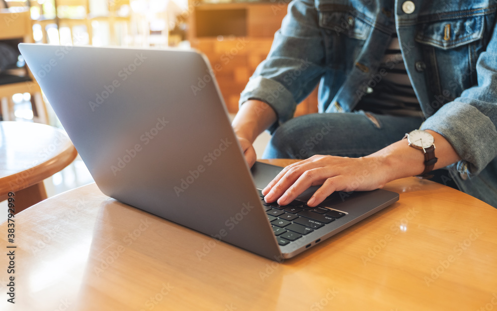 Fototapeta premium Closeup image of a woman working and typing on laptop computer keyboard on the table
