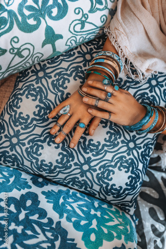 close up of woman hands with accessories lying on designers pillows