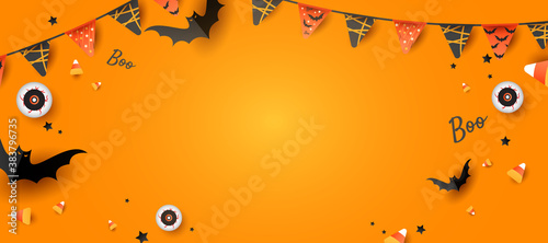 Spooky and fun Halloween design frame with eyeball, color candy, decorations, bats on orange background with copy space. Horizontal holiday poster, header for website