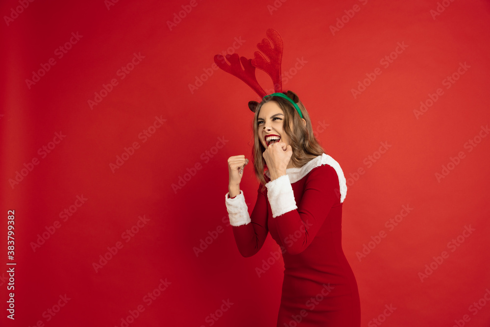 Winner, celebrating. Concept of Christmas, 2021 New Year's, winter mood, holidays. Copyspace for ad, postcard. Beautiful caucasian woman with long hair like Santa's Reindeer catching giftbox.