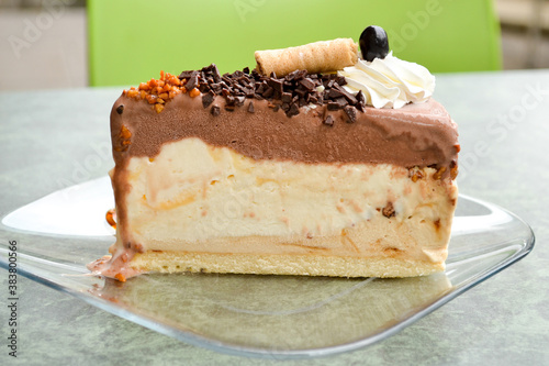 Piece of delicious layered souffle cake with plazma cookies and chocolate
