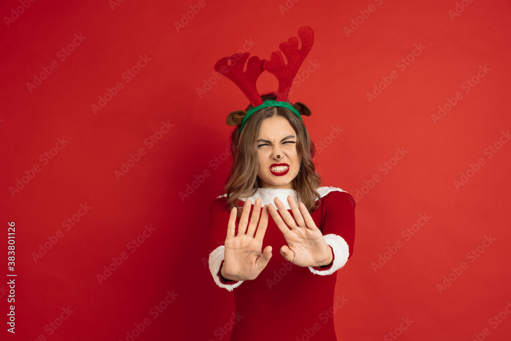 Rejecting, stopping. Concept of Christmas, 2021 New Year's, winter mood, holidays. Copyspace for ad, postcard. Beautiful caucasian woman with long hair like Santa's Reindeer catching giftbox.