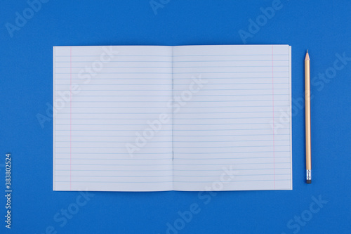 school notebook with pencil on blue table top view