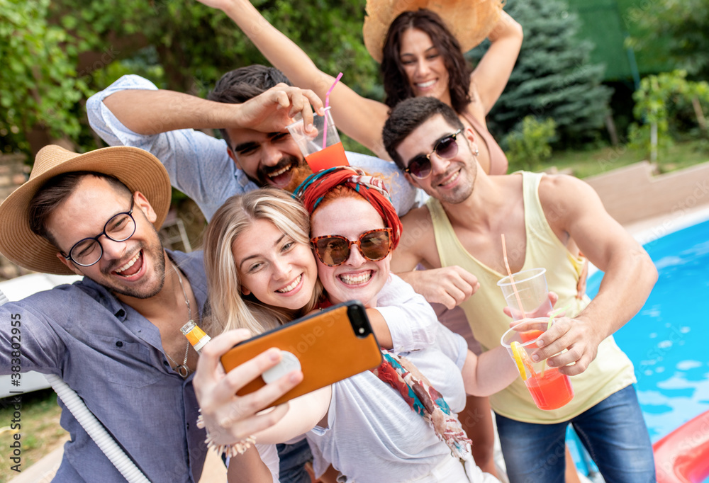 Group of young people having fun at summer vacation and enjoying a poolside party with drinks and making selfie. Group of young people having fun at summer vacation and enjoying a poolside party with drinks and making selfie.