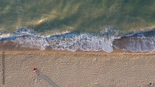 A loving couple walking along the coastline at the sea on a sunny morning photo