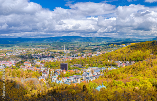 Karlovy Vary city aerial panoramic view with row of colorful multicolored buildings and spa hotels in historical city centre. Panorama of Karlsbad town and Ore mountain range in autumn