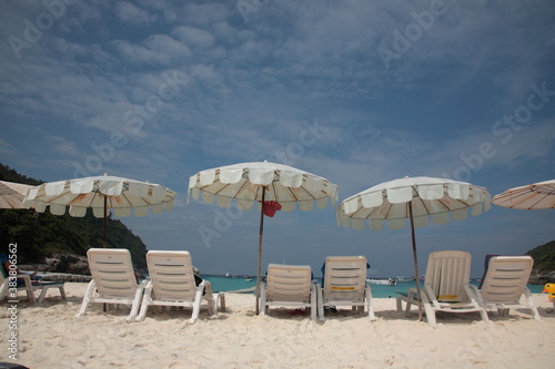 Tourists swimming and Snorkeling at beach with resort outdoor sunshade and chairs on the tropical island in Phuket  Thailand. 