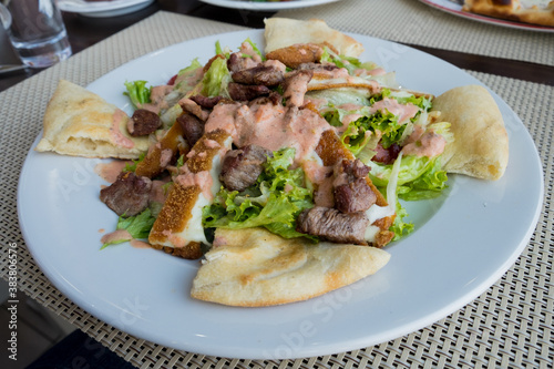 Meat caesar - beef salad with toasted bread, cherry tomatoes and cheese sauce