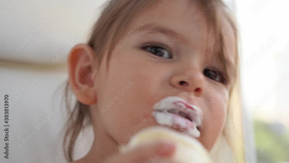 Child toddler girl with ice cream at home. Tasty yummy sweet food. Funny face Child toddler girl with ice cream at home. Tasty yummy sweet food. Funny face