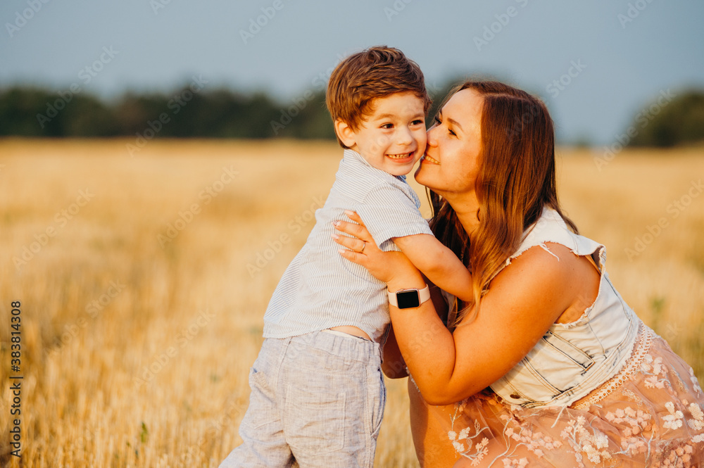 Cute cheerful child son with mother in field Cute cheerful child son with mother in field