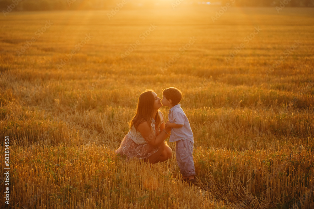 Cute cheerful child son with mother in field Cute cheerful child son with mother in field