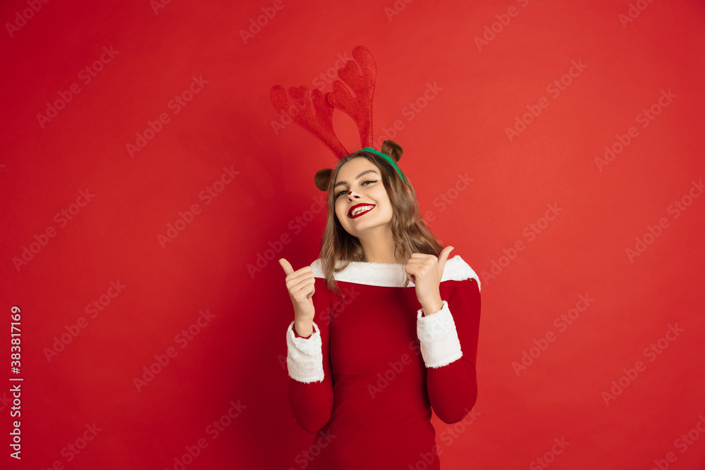 Pointing. Greetingcard. Concept of Christmas, 2021 New Year's, winter mood, holidays. Copyspace for ad, postcard. Beautiful caucasian woman with long hair like Santa's Reindeer catching giftbox. Pointing. Greetingcard. Concept of Christmas, 2021 New Year's, winter mood, holidays. Copyspace for ad, postcard. Beautiful caucasian woman with long hair like Santa's Reindeer catching giftbox.