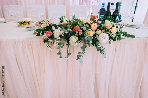 Wedding table decorated with bouquet with roses, eustoma and eucalyptus leaves. © jul14ka