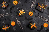 Halloween holiday background with gifts and decorations on black backdrop.