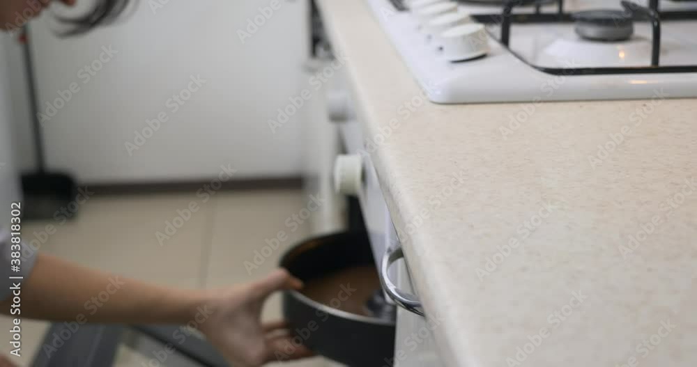 Housewife Cooking Baking Chocolate Cake in Gas Stove. Kitchen at Home. Blurred Shallow DOF Housewife Cooking Baking Chocolate Cake in Gas Stove. Kitchen at Home. Blurred Shallow DOF