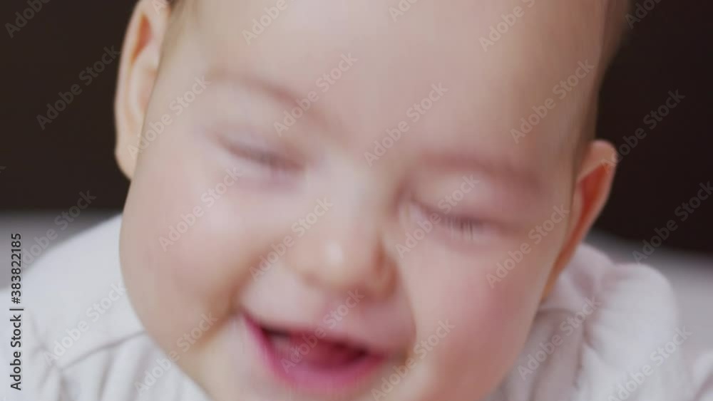 Beautiful Smiling Baby: A gorgeous little baby lies on the bed and smiles at the camera with a nice soft focus background. Beautiful Smiling Baby: A gorgeous little baby lies on the bed and smiles at the camera with a nice soft focus background.