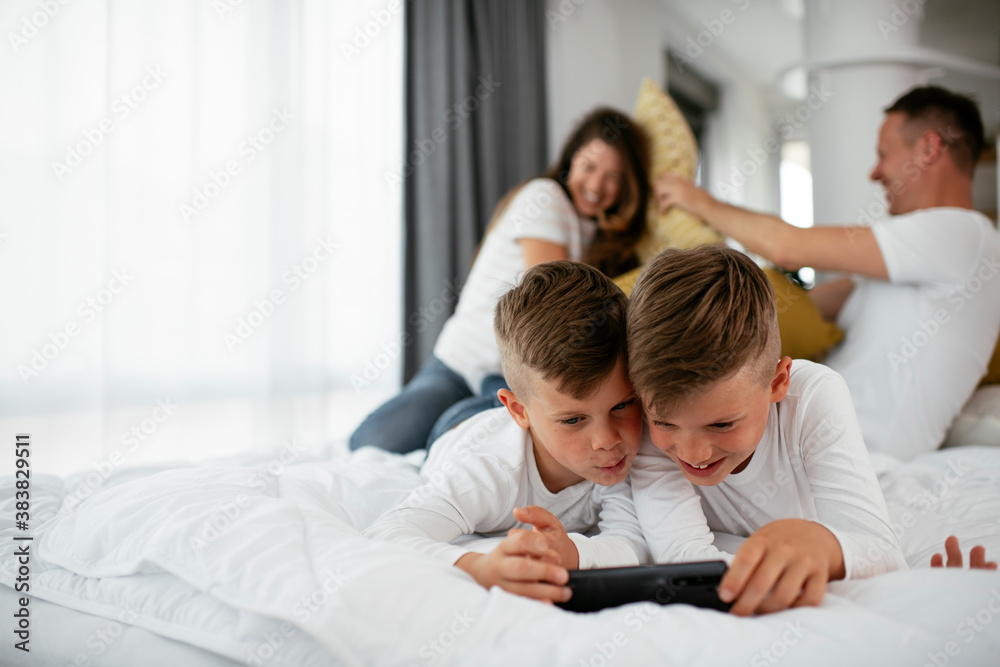 Two little brothers are playing games on the phone. Beautiful boys enjoying at home. Two little brothers are playing games on the phone. Beautiful boys enjoying at home.
