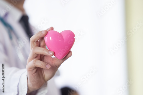 close up hand male doctor holding pink heart, healhtcare concept.