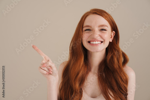 Ginger half-naked happy girl laughing and pointing finger aside